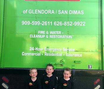 Three children on back of green truck