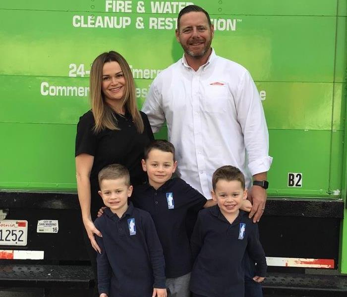 Family standing in front of green truck